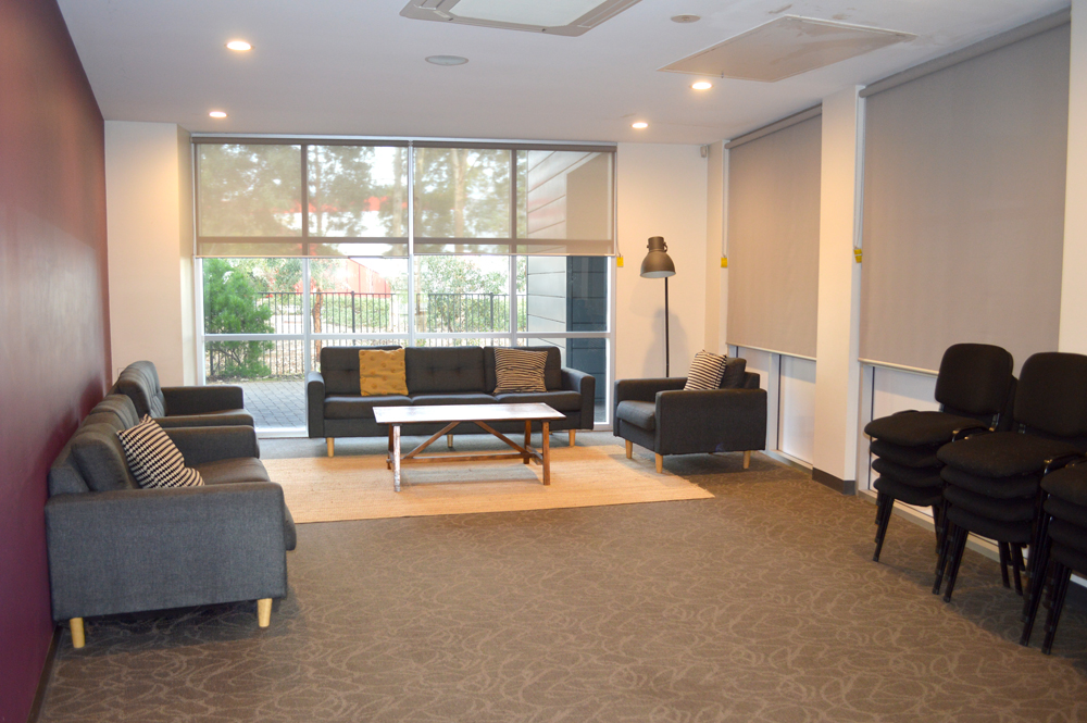 The smaller lounge is a cozy room ready for friendly chats with multiple couches, rug on the the floor and coffee table between.